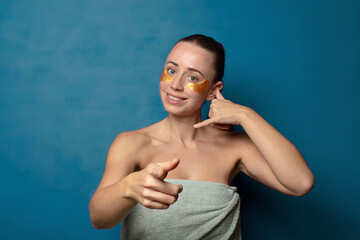 smiling cheerfully and pointing to camera while making a call you later gesture, talking on phone