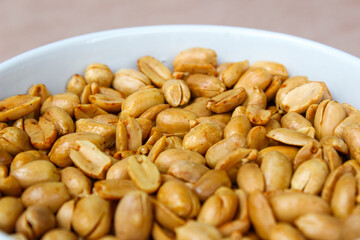 Close up of Roasted salted peanut on a white bowl