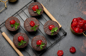 Deliciously rich chocolate brownies garnished with vibrant cherries and mint leaves, resting on a...