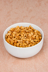 Roasted salted peanut on a white bowl