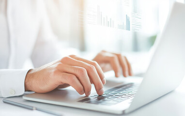 Businessman typing on laptop in professional environment, focused on data analysis and productivity