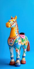 a miniature yoke horse toy set against a bright blue background, with detailed floral patterns painted on the yoke