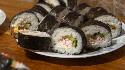 Sliced ​​sushi rolls on a white plate close-up