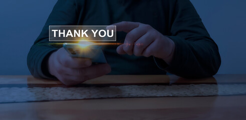Digital appreciation and gratitude concept with glowing 'Thank You' text above a smartphone in a...