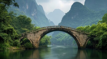 An ancient rice bridge made of stone arches gracefully across the river, nestled in a deep mountain gorge.