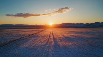 A serene sunset over a snow-covered landscape, casting long shadows and warm hues.