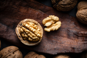 Cracked walnut with kernels on old wooden plank close up. Food photography