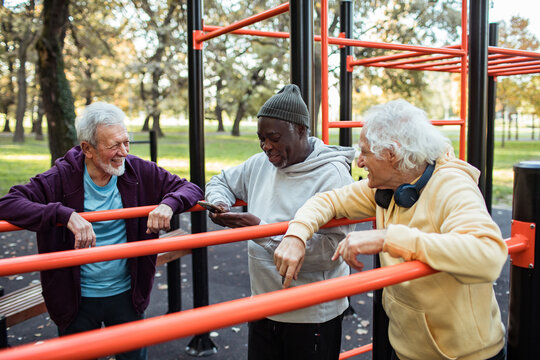 Diverse senior male friends working out together at park