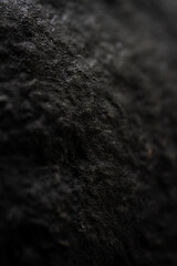 Extreme close up of painted in black handmade paper clay with a structure and rough texture. Paper recycling. Selective focus, shallow depth of field.
