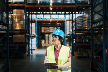 Female warehouse worker inspecting inventory with clipboard