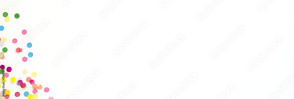 Poster colorful confetti is scattered across a plain white surface, adding festive flair to a simple flat l