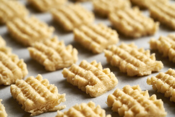 Closeup of raw Christmas cookies on a baking sheet before baking