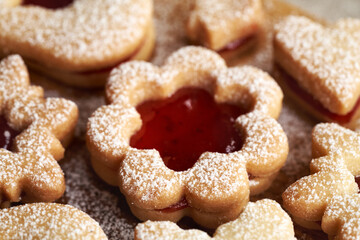 Flower shaped traditonal Linzer Christmas cookie filled with strawberry marmalade and dusted with sugar
