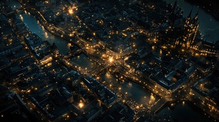 Night aerial view of a city with canals and bridges illuminated.