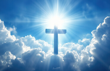 Spiritual light shines through clouds illuminating a cross in the sky above a serene landscape. Blue sky, white clouds, and rays of sunlight shining down from the above.