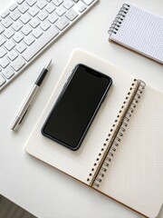 Desk workspace setup featuring a smartphone, notebook, and pen arranged neatly. notebook and pen on the table
