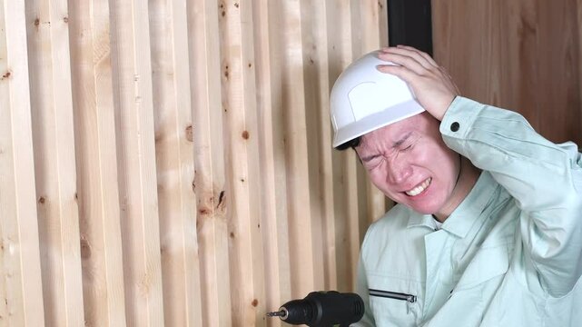 現場で電動ドリルで作業中に困る男性作業員