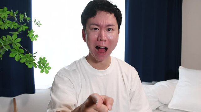 怒っている最中の私服姿の若いアジア人男性