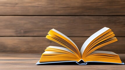 Open Book with Yellow Pages on Wooden Table Background