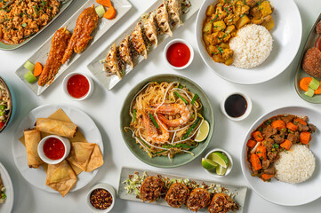 Set of Thai dishes top view on white background. Composition of traditional Asian food with noodles, pad thai, ramen, chicken massaman, beef panang, stuffed dumplings.