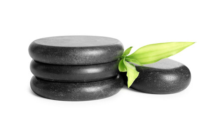 Spa stones and green leaves isolated on white