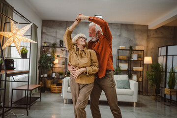 senior couple husband and wife love dance and hug at home have fun
