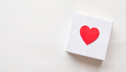 Fototapeta premium White gift box with a red heart on top, placed on a light background, Valentine's Day, Heart Health Month