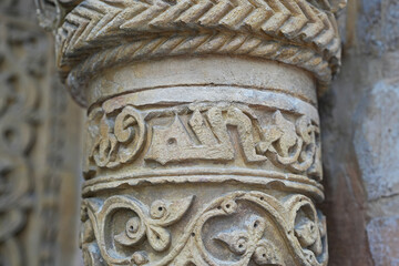 A historical building framed with artistically carved stonework. Architectural detail from the Divriği Great Mosque and Hospital, listed on the UNESCO World Heritage List. Floral and geometric motifs.