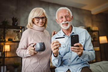 Fototapeta premium senior husband and wife buy online on cellphone with credit card
