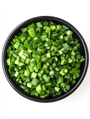 Chopped green onion in a black ceramic bowl isolated on white background. Top view.