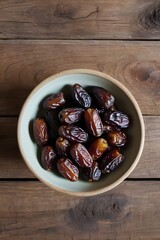 A tiny bowl of dates on a wooden table old