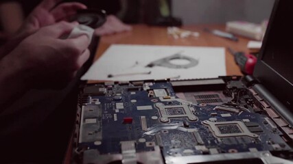 Man using tools repairing his laptop, high angle view. Professional technician working in computer service, flat lay. Checking and diagnosing the operation of the motherboard