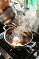 A rustic tea kettle on a wooden stove, with glowing steam under cinematic light.
