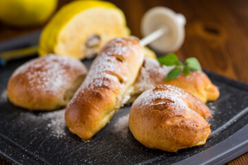 Pastries. Sweet buns with quince and honey filling, on a wooden table