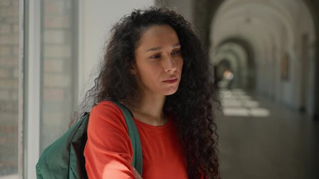 Sad frustrated lonely upset stressed depressed pensive thinking Hispanic woman Latina girl student female in university college academy corridor learning studying problem education failure bullying