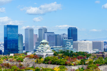 Colorful cityscape of Osaka castle and Osaka city in autumn season with white cloud and blue sky background, Japan. Top view. Landmark of Osaka.