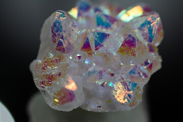A rainbow aura quartz crystal cluster radiates vibrant, iridescent hues, combining natural beauty with mystical energy and gemstone brilliance, isolated in studio