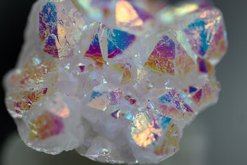 A rainbow aura quartz crystal cluster radiates vibrant, iridescent hues, combining natural beauty with mystical energy and gemstone brilliance, isolated in studio