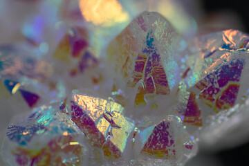A rainbow aura quartz crystal cluster radiates vibrant, iridescent hues, combining natural beauty with mystical energy and gemstone brilliance, isolated in studio