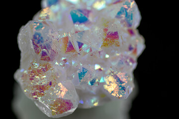 A rainbow aura quartz crystal cluster radiates vibrant, iridescent hues, combining natural beauty with mystical energy and gemstone brilliance, isolated in studio