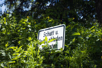 Schild verbietet das Abladen von Schutt und Unrat im Wald