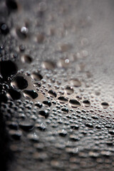 Close Up of Condensation Floating Liquid Water Bubbles and Drips on Glass from Rain
