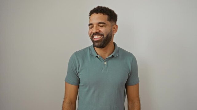 Man standing confident and laughing with natural expression, young hispanic male looking away with a smile on his face over isolated white background