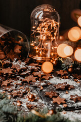 Traditional Christmas gingerbread cookies on a dark background with bokeh lights. Vertical photo, Holiday Season activity.