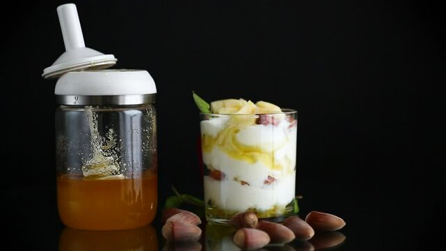 sweet homemade yogurt in a glass with apples, nuts and honey