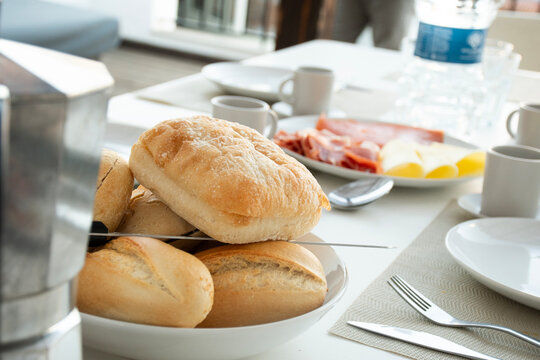 close up on ciabatta bread and breakfast cold cuts platter with smoked salmon, copa ham and cheeses on cafe table