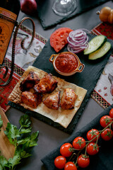 Grilled meat with vegetables and sauce on rustic slate platter