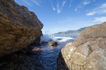Panoramic view of the Mediterranean Sea near the rocky shores and sea spray between the rocks.