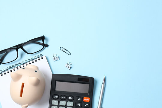 Top above overhead view photo of office accessories calculator, glasses, notebook and pen on color backdrop with blank empty space