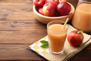 Tasty apple juice and fresh fruits on wooden table. Space for text